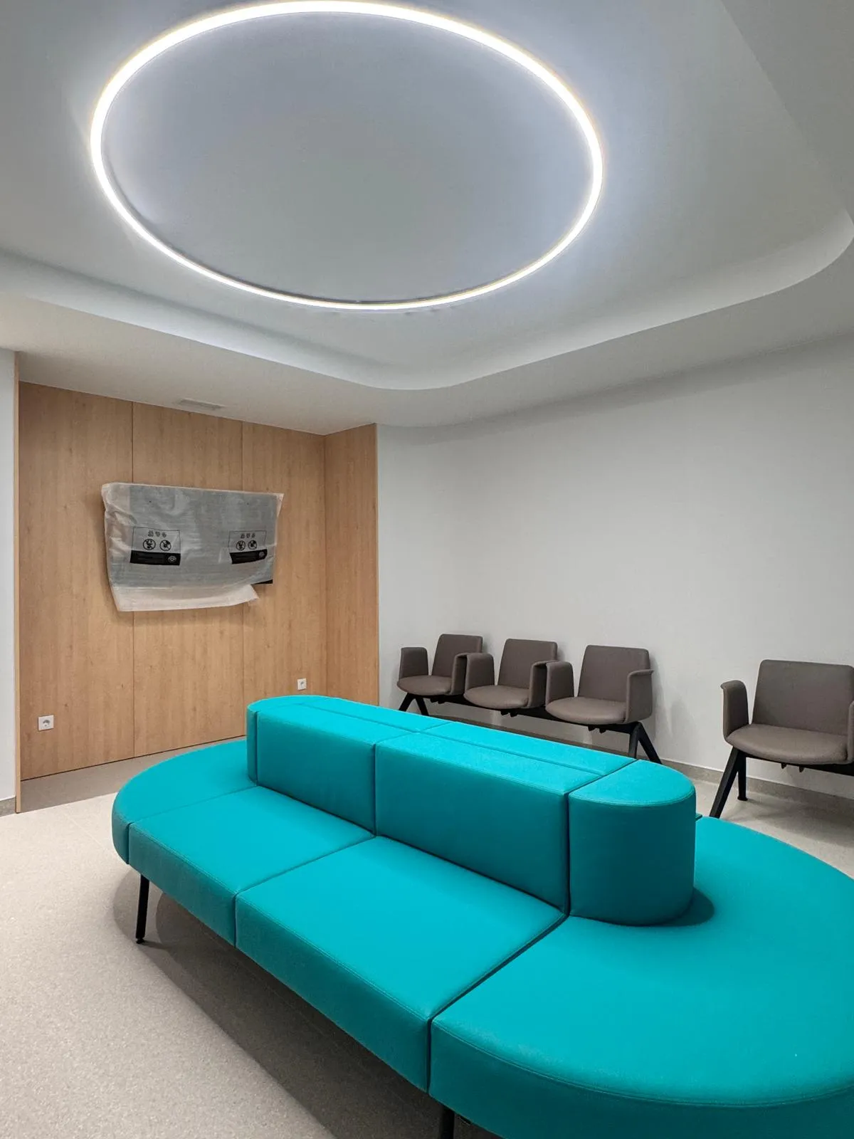 Sala de espera da Clínica Almada Care, com o sofá turquesa da marca sob luz suave.