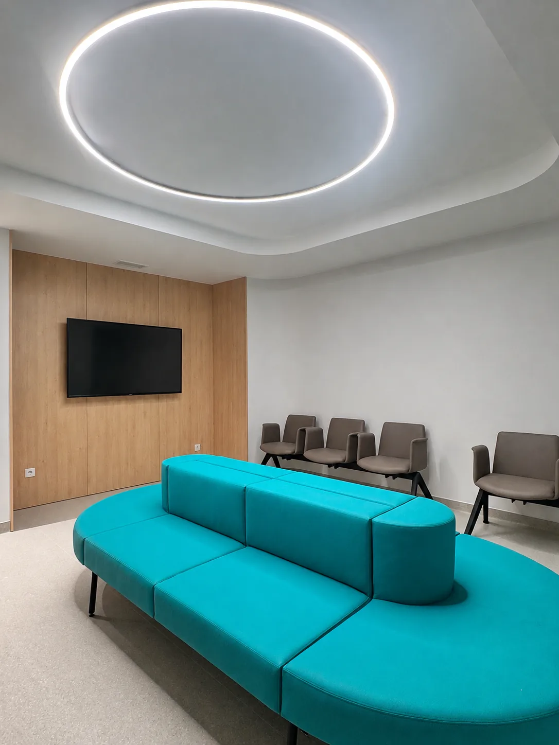 Sala de espera da Clínica Almada Care, com o sofá turquesa da marca sob luz suave.